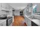 Open kitchen featuring white cabinets, hardwood floors, and leads to the living area at 33 Moriah Ne Way, Rydal, GA 30171