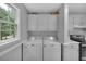 Functional laundry room with cabinets, countertops, and exterior window at 33 Moriah Ne Way, Rydal, GA 30171