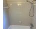 Shower over tub with tile surround, handheld shower head, and chrome fixtures at 5000 Saxony Ct, Stone Mountain, GA 30083