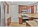 Well-equipped kitchen with stainless steel appliances, wood cabinets, granite countertops and an adjacent door at 747 Gardenside Se Cir, Marietta, GA 30067