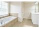 Relaxing bathroom with a soaking tub, a separate vanity, and a window for natural light at 296 Water Oak Pl, Alpharetta, GA 30009