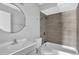 Clean bathroom featuring a round mirror, modern vanity, with a shower and tub combo with neutral tiling at 2972 Parc Lorraine, Lithonia, GA 30038