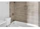 Bathroom featuring a white toilet with a bathtub shower combo and inset shelving in the neutral tiled surround at 2972 Parc Lorraine, Lithonia, GA 30038