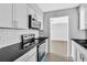 Modern kitchen featuring white cabinetry, stainless steel appliances, and sleek black countertops at 2972 Parc Lorraine, Lithonia, GA 30038