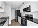 Modern kitchen featuring white cabinetry, stainless steel appliances, and sleek black countertops at 2972 Parc Lorraine, Lithonia, GA 30038