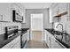Modern kitchen featuring white cabinetry, stainless steel appliances, and sleek black countertops at 2972 Parc Lorraine, Lithonia, GA 30038