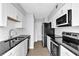 Modern kitchen featuring white cabinetry, stainless steel appliances, and sleek black countertops at 2972 Parc Lorraine, Lithonia, GA 30038