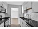 Modern kitchen featuring white cabinets, subway tile backsplash, and sleek black countertops at 2972 Parc Lorraine, Lithonia, GA 30038