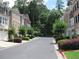 A view of homes lining a street, with mature trees and shrubs and well-maintained curbsides at 2975 Wintercrest Trce, Dunwoody, GA 30360