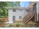 Exterior backyard elevation with painted brick, wood deck stairs, small garden area, and perimeter fence at 86 Stratford Nw Dr, Atlanta, GA 30311