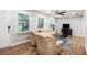 Bright living room featuring hardwood floors, two windows with blinds, and an elegant ceiling fan at 86 Stratford Nw Dr, Atlanta, GA 30311