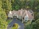 Aerial view of estate home surrounded by lush trees and foliage and circular drive at 1500 Historic Vw, Stone Mountain, GA 30087