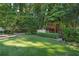 Lush backyard featuring mature trees, manicured lawn, and a charming playhouse at 1500 Historic Vw, Stone Mountain, GA 30087