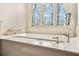 Relaxing bathroom with a soaking tub positioned in front of a window with views of the trees at 1500 Historic Vw, Stone Mountain, GA 30087
