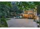 Stately home featuring a large driveway, landscaped grounds, a pool, and warm exterior lighting at 1500 Historic Vw, Stone Mountain, GA 30087