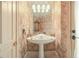 Charming powder room featuring patterned wallpaper, a unique pedestal sink and elegant lighting at 1500 Historic Vw, Stone Mountain, GA 30087