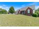 A brick home features a well-manicured lawn, mature trees, and a welcoming front porch at 20 Friendship Rd, Euharlee, GA 30145