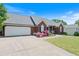 Charming brick home features a two-car garage, well-manicured lawn, and colorful flower beds at 20 Friendship Rd, Euharlee, GA 30145