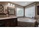 Main bathroom featuring a vanity with large soaking tub under a window at 20 Friendship Rd, Euharlee, GA 30145
