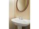 A well-lit bathroom with a pedestal sink and an oval mirror in a clean and simple design at 2774 Birch Grove Se Ln # 11, Marietta, GA 30067