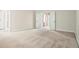 A bright empty bedroom with neutral carpet flooring and white trim. Ready to be furnished at 2774 Birch Grove Se Ln # 11, Marietta, GA 30067