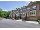 Beautiful townhome exteriors with brick accents, driveways, and street parking with tree line in the background at 2774 Birch Grove Se Ln # 11, Marietta, GA 30067