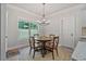 Bright dining area with wood table, elegant chandelier, and natural light streaming through a large window at 902 Edgewater Dr, Loganville, GA 30052