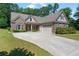 Beautiful single-Gathering home with a brick exterior, lush green lawn, and an expansive concrete driveway leading to a two-car garage at 902 Edgewater Dr, Loganville, GA 30052