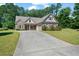 Inviting brick home featuring a well-maintained lawn and a spacious concrete driveway leading to an attached two-car garage at 902 Edgewater Dr, Loganville, GA 30052
