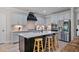 Contemporary kitchen with white cabinets, a black center island, and stainless steel appliances at 902 Edgewater Dr, Loganville, GA 30052