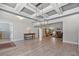 Open concept living area featuring hardwood floors, coffered ceilings, and a fireplace, perfect for Gathering gatherings at 902 Edgewater Dr, Loganville, GA 30052