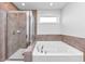 Bathroom featuring separate shower and tub with tile surround and modern fixtures for a luxurious experience at 109 Paulownia Cir, Mcdonough, GA 30253