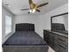Bedroom featuring ample light, a ceiling fan, a bed, and a matching dark dresser at 109 Paulownia Cir, Mcdonough, GA 30253
