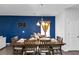 Formal dining room boasts modern chandelier and an accent wall with dining table at 109 Paulownia Cir, Mcdonough, GA 30253