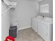 Well-organized laundry room with a washer, dryer, overhead shelving, and vinyl floors at 109 Paulownia Cir, Mcdonough, GA 30253