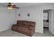 Cozy living room features neutral walls, ceiling fan, and brown sofa at 109 Paulownia Cir, Mcdonough, GA 30253