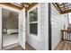 View of the white siding on the house with a small outdoor balcony with pergola overlooking the lawn at 319 Hayden Cir, Woodstock, GA 30189