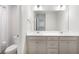 Bright, modern bathroom with double vanity, white cabinets, a large mirror, and a shower with a white curtain at 319 Hayden Cir, Woodstock, GA 30189