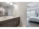 Modern bathroom featuring double vanity with gray cabinets and a glass-enclosed shower, with a glimpse into the bedroom at 319 Hayden Cir, Woodstock, GA 30189