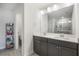 Stylish bathroom featuring dual sinks, a large mirror, gray cabinets, and a glass-enclosed shower at 319 Hayden Cir, Woodstock, GA 30189