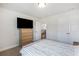 Bright bedroom with light carpet, a dresser with a TV, and access to the upstairs hallway and stairs at 319 Hayden Cir, Woodstock, GA 30189