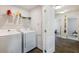 Functional laundry room with modern white washer and dryer and an upper shelf for storing detergents and cleaning supplies at 319 Hayden Cir, Woodstock, GA 30189