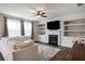 Bright living room featuring a fireplace, built-in shelving, ceiling fan, and modern decor at 319 Hayden Cir, Woodstock, GA 30189