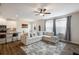 Open-concept living room seamlessly connects to the kitchen, complete with modern furnishings and a ceiling fan at 319 Hayden Cir, Woodstock, GA 30189