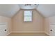 Carpeted attic room with neutral walls, a window, and access doors on either side at 1635 Lake Heights Cir, Dacula, GA 30019