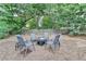 Relaxing backyard setting with a cozy fire pit area surrounded by mature trees at 1635 Lake Heights Cir, Dacula, GA 30019