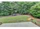 Expansive backyard with manicured lawn, mature trees, seating area and games at 1635 Lake Heights Cir, Dacula, GA 30019