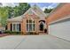 Brick home with a well-manicured lawn, arched windows, and a two-car garage at 1635 Lake Heights Cir, Dacula, GA 30019