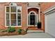 Charming brick home featuring an arched doorway and manicured landscaping at 1635 Lake Heights Cir, Dacula, GA 30019
