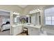 Main bathroom with double sinks, vanity, tub, and large mirror at 1635 Lake Heights Cir, Dacula, GA 30019
